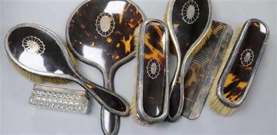 Seven silver and tortoiseshell mounted dressing table items.